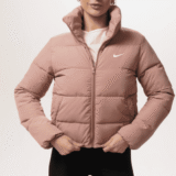 Жіноча легка пудрова куртка Nike з високим коміром та логотипом на грудях. Женская легкая пудровая куртка Nike с высоким воротником и логотипом на груди.