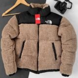 Зимова унісекс-куртка "Тедді" від The North Face кольору мокко, виконана з м'якого плюшевого матеріалу з контрастною чорною вставкою. Зимняя унисекс-куртка "Тедди" от The North Face цвета мокко, выполненная из мягкого плюшевого материала с контрастной черной вставкой.