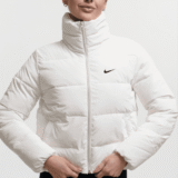 Жіноча легка біла куртка Nike з високим коміром та логотипом на грудях. Женская легкая белая куртка Nike с высоким воротником и логотипом на груди.