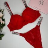 Комплект червоної мереживної жіночої білизни Victoria's Secret, що складається з бюстгальтера та трусиків зі стразами на поясі. Комплект красного кружевного женского белья Victoria's Secret, состоящий из бюстгальтера и трусиков со стразами на поясе.