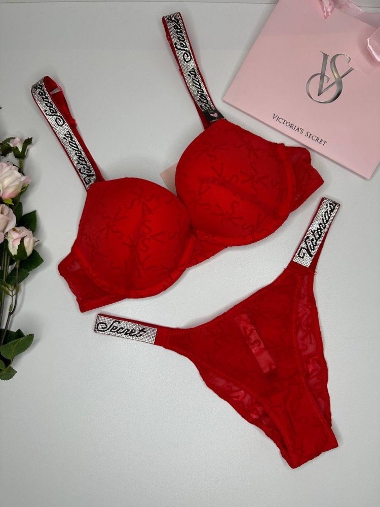Комплект червоної мереживної жіночої білизни Victoria's Secret, що складається з бюстгальтера та трусиків зі стразами на поясі. Комплект красного кружевного женского белья Victoria's Secret, состоящий из бюстгальтера и трусиков со стразами на поясе.