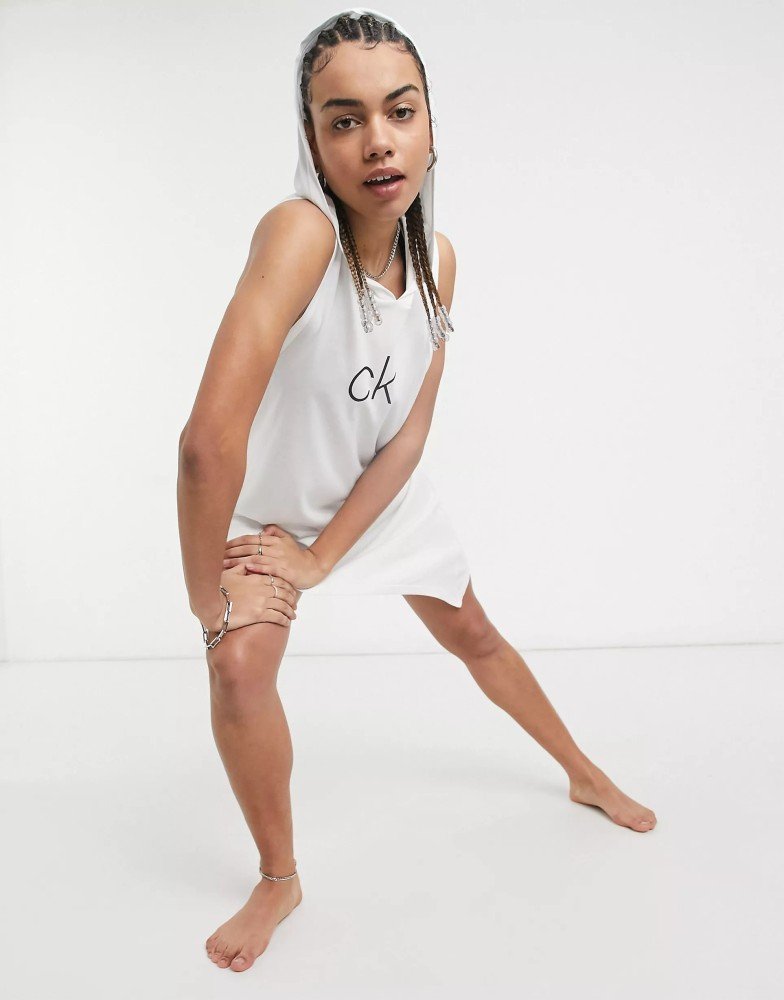 Жіноча біла пляжна туніка-плаття Calvin Klein з капюшоном та написом "CK" на грудях. Женская белая пляжная туника-платье Calvin Klein с капюшоном и надписью "CK" на груди.